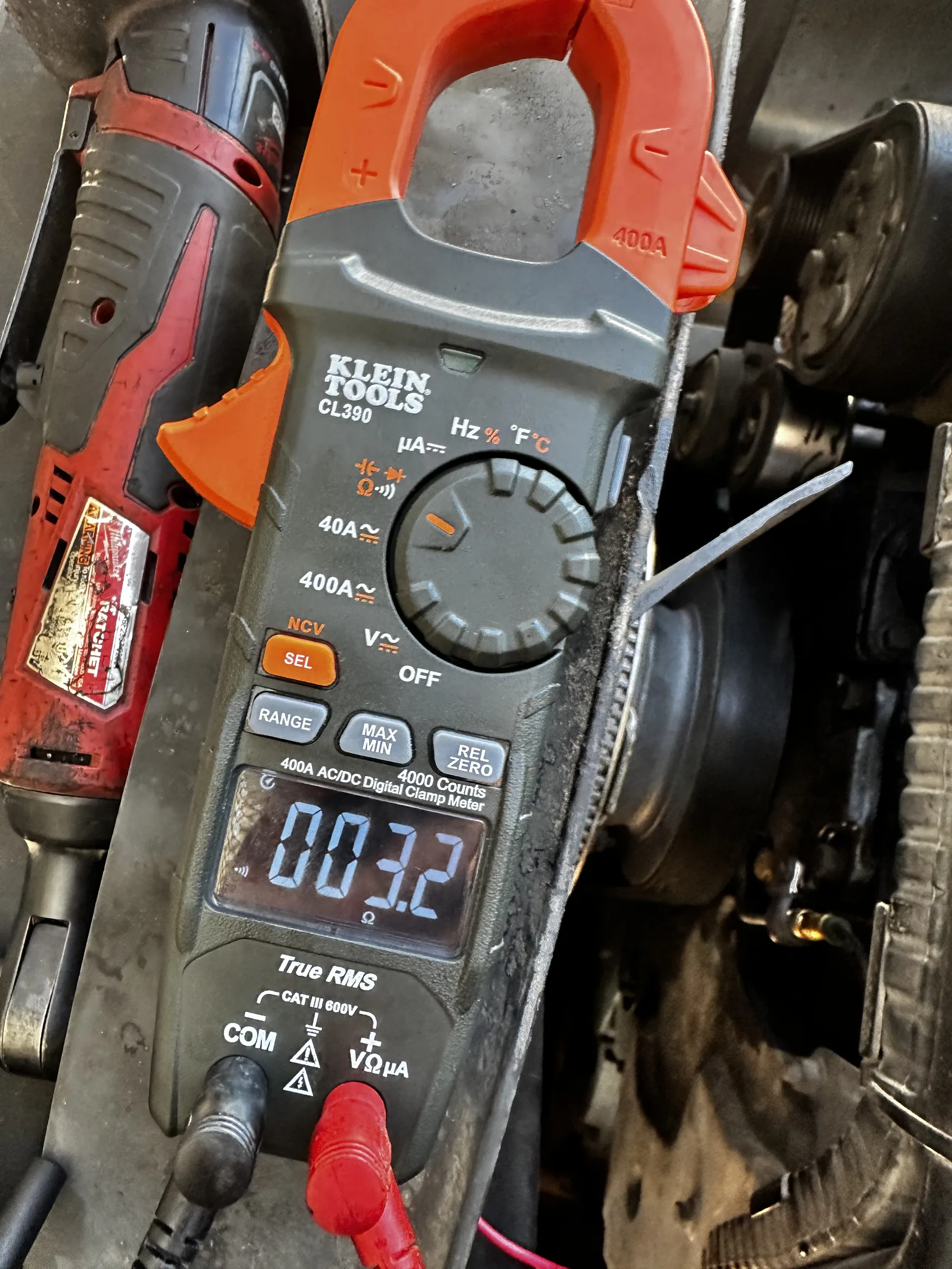 Clamp meter clamped on a wire during electrical diagnosis