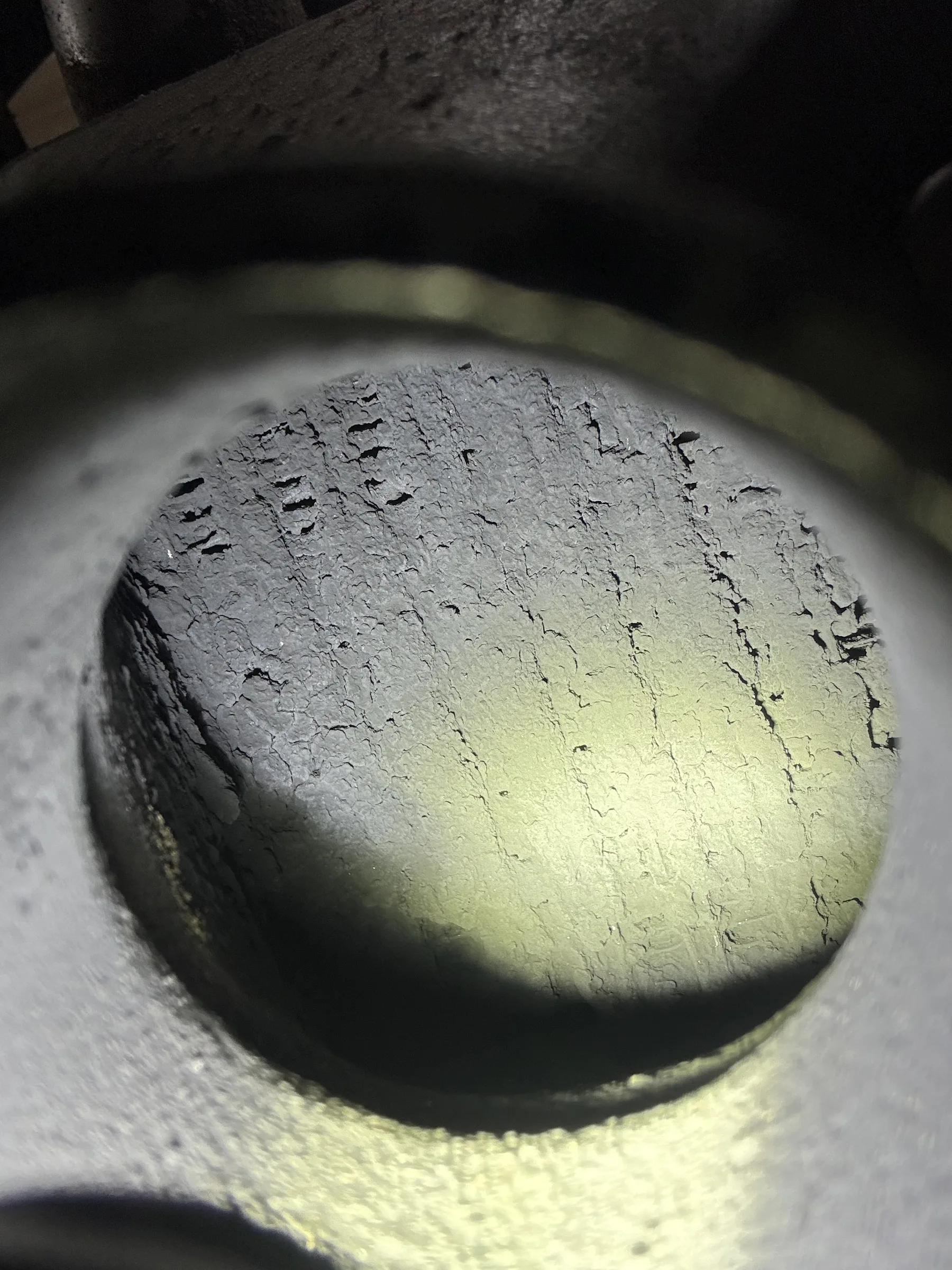 Macro view inside an engine cylinder bore lit by a flashlight