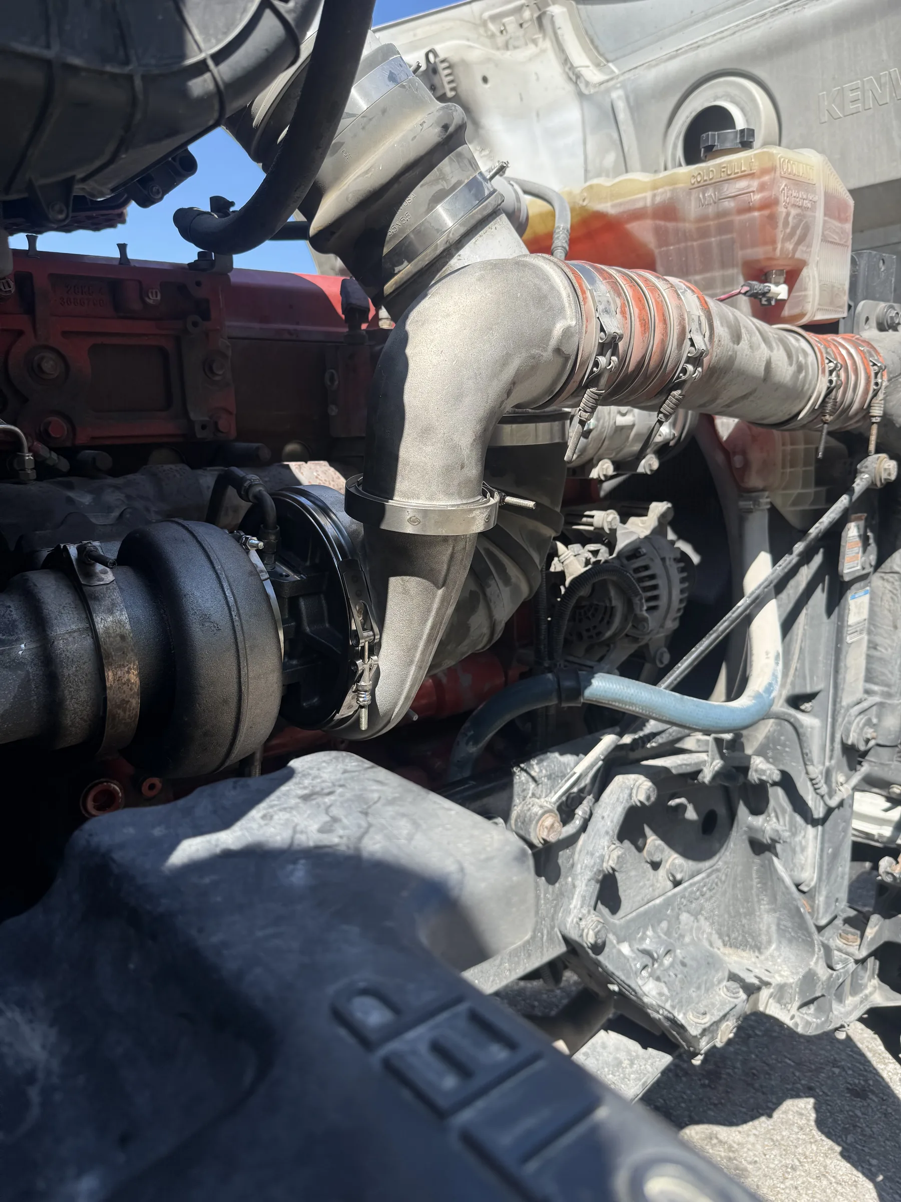 Engine bay with intake plumbing and alternator visible
