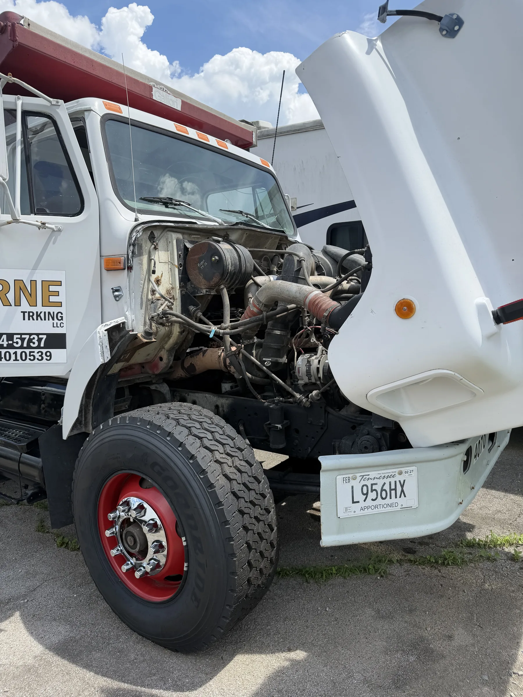 Service truck working on a customer truck with the hood up
