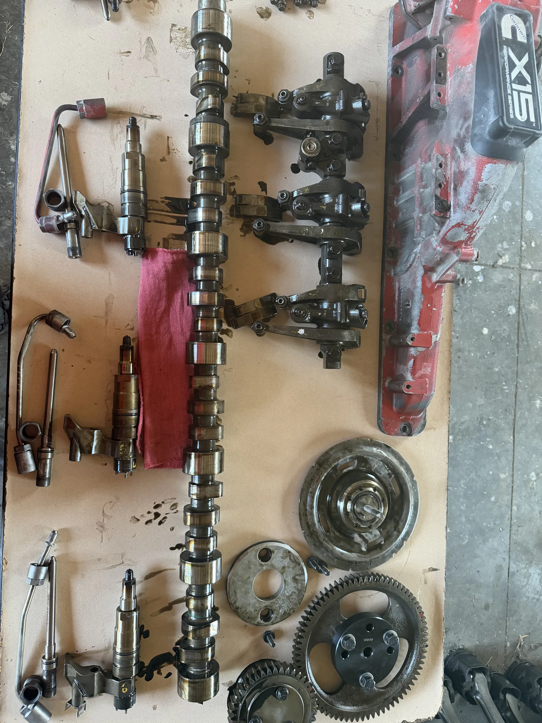 Heavy-duty diesel valve-train components laid out — camshaft, rocker assemblies, gears, injectors