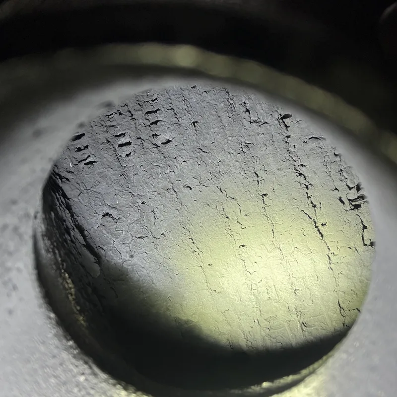 Macro view inside an engine cylinder bore lit by a flashlight