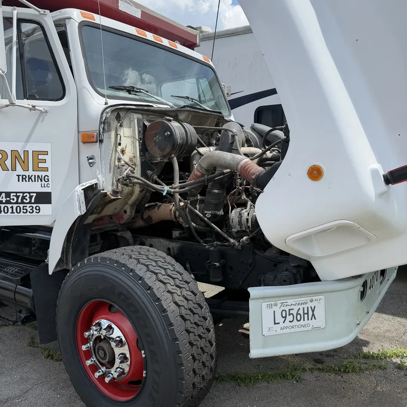Service truck working on a customer truck with the hood up